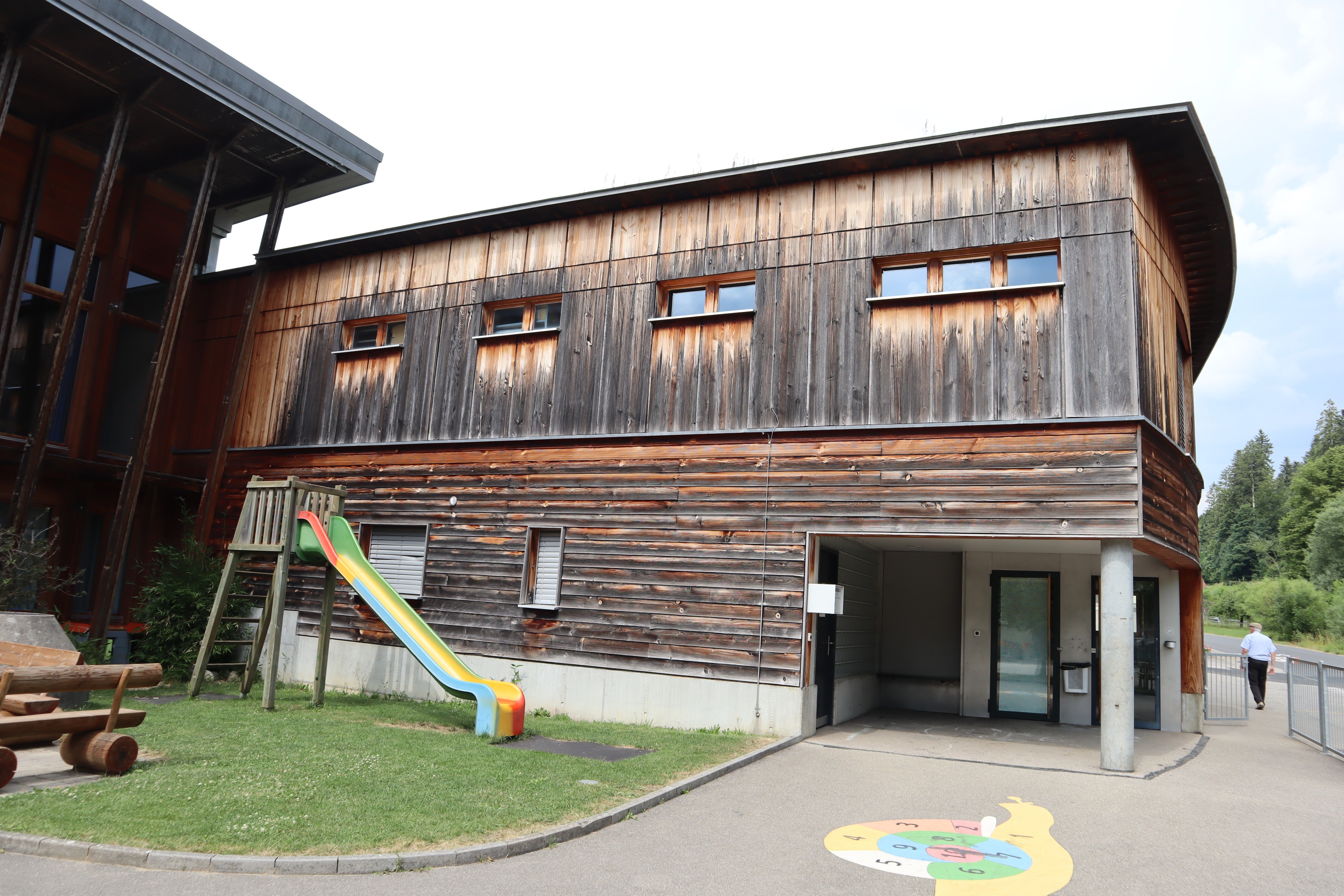 Die Risse in der Holzverkleidung  der Mehrzweckanlage kosten Energie